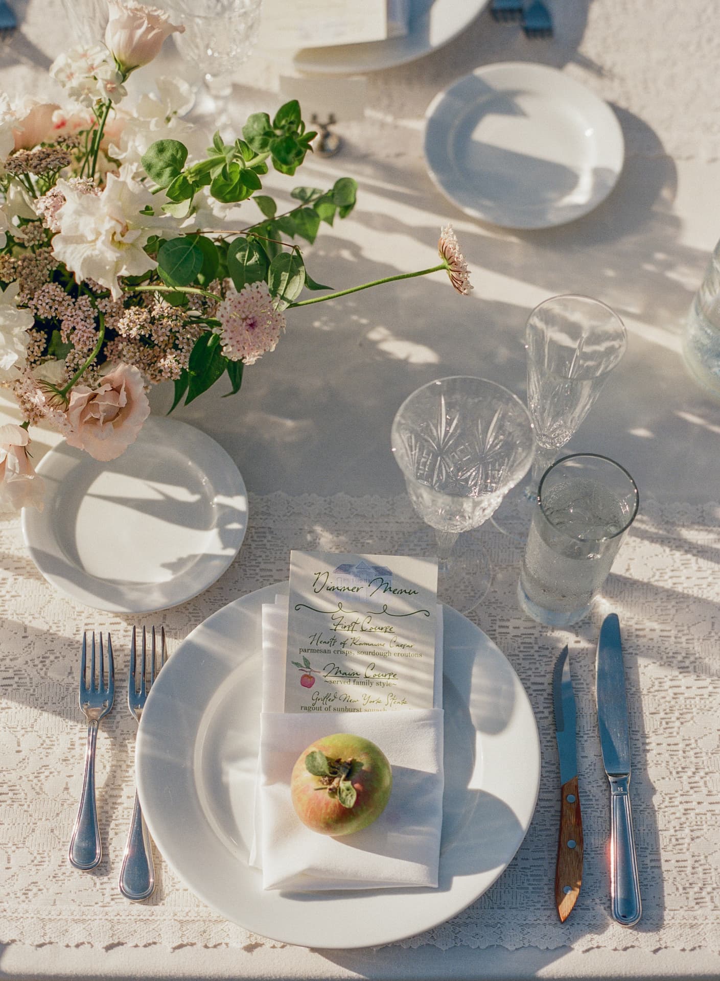 Elegant reception place setting with blush florals and blue flatware