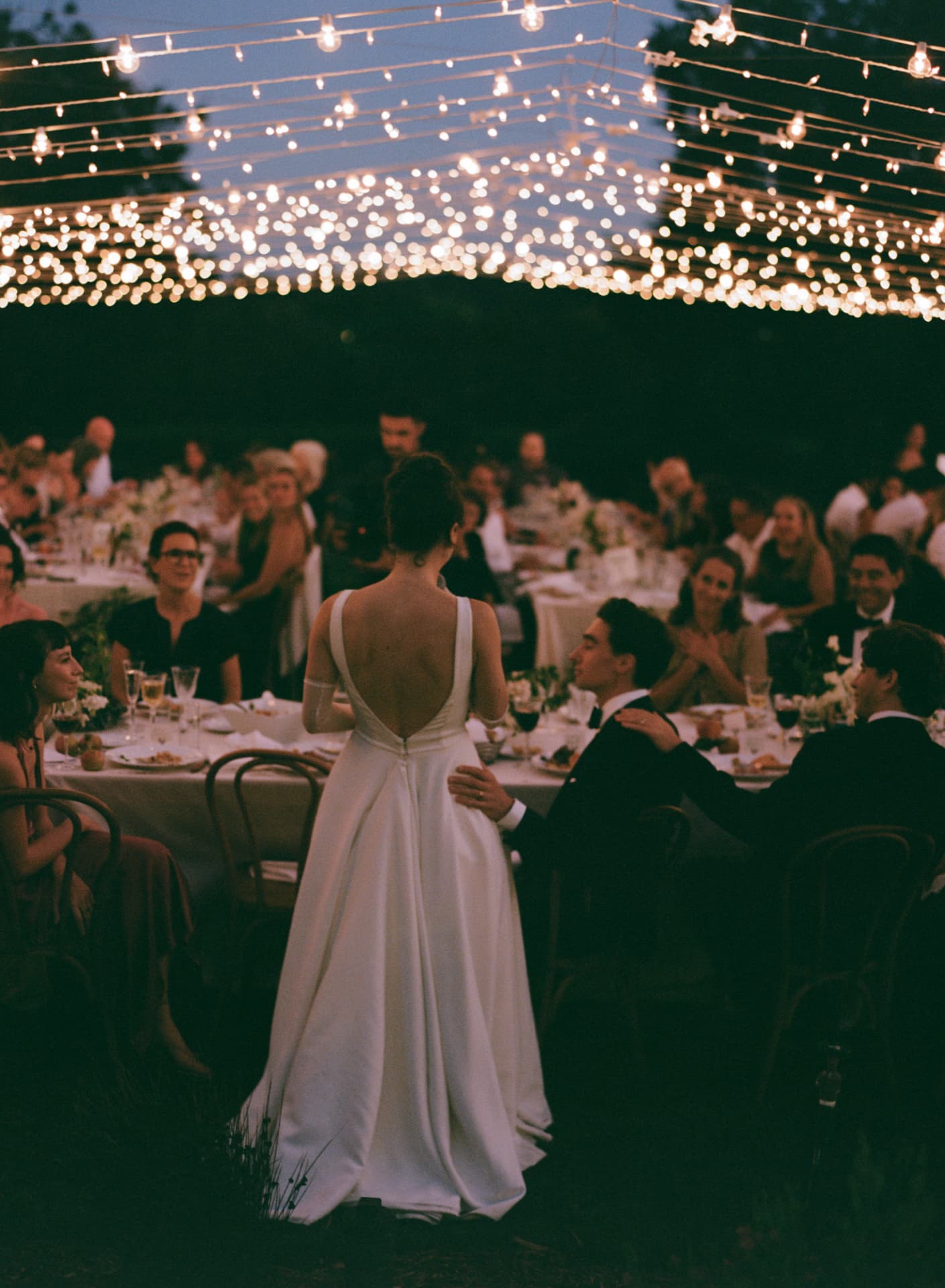 Bride during her first dance beneath a canopy of string lights