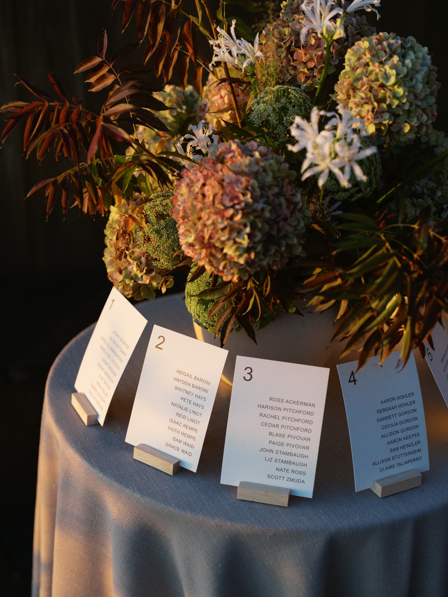 Escort card display at golden hour with autumn hydrangea florals