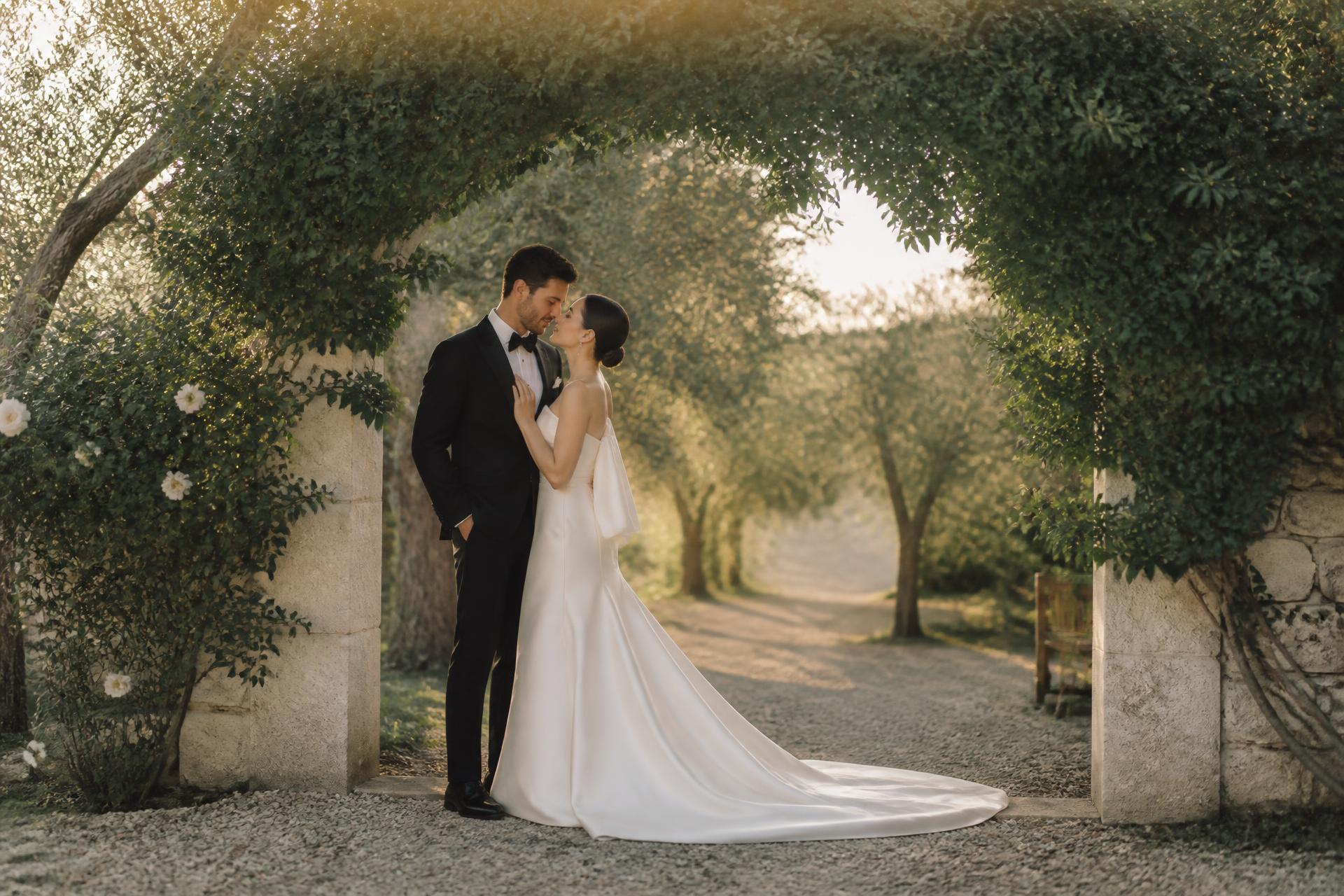 Bride and groom beneath a garden arbor